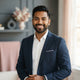 A smiling, diverse young man looking at the camera, presented as a professional customer portrait for a trust testimonial.